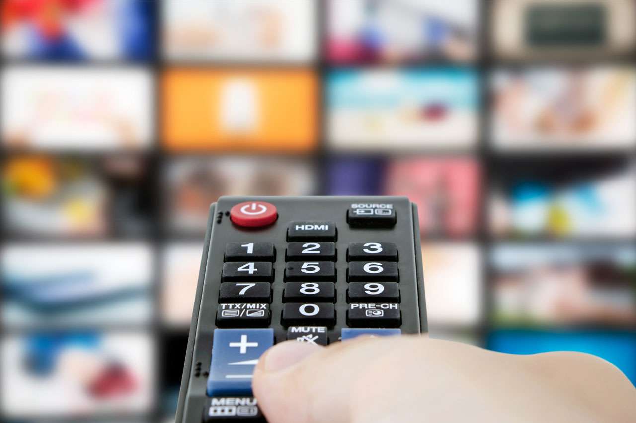 Person holding a remote pointed at a TV