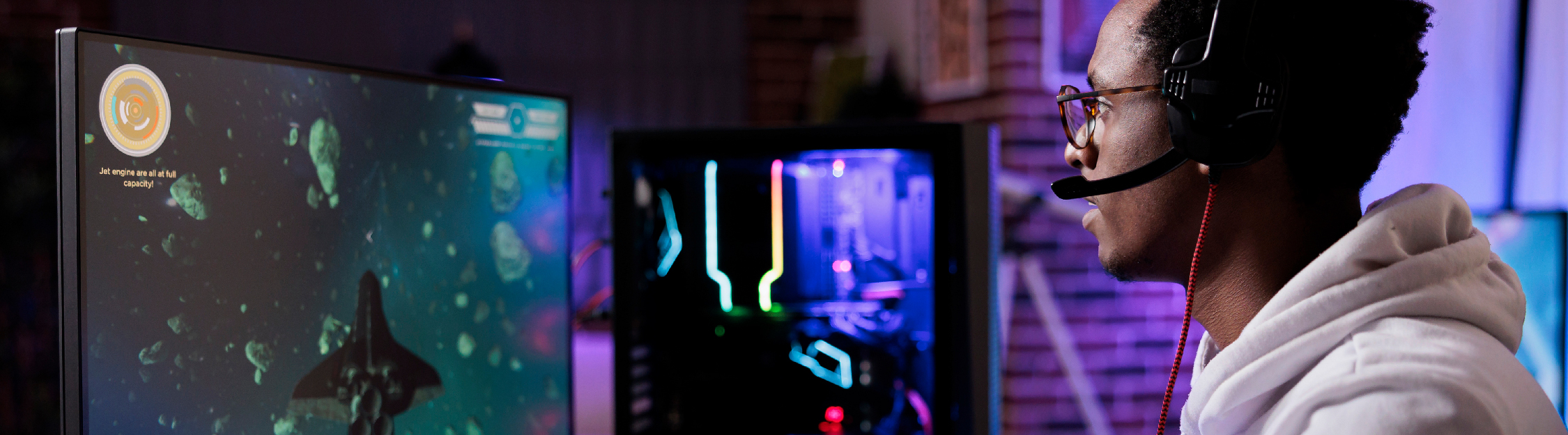 Young African American man uses colorful monitors for gaming