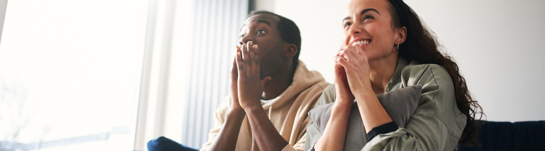 Couple watches exciting TV show from couch