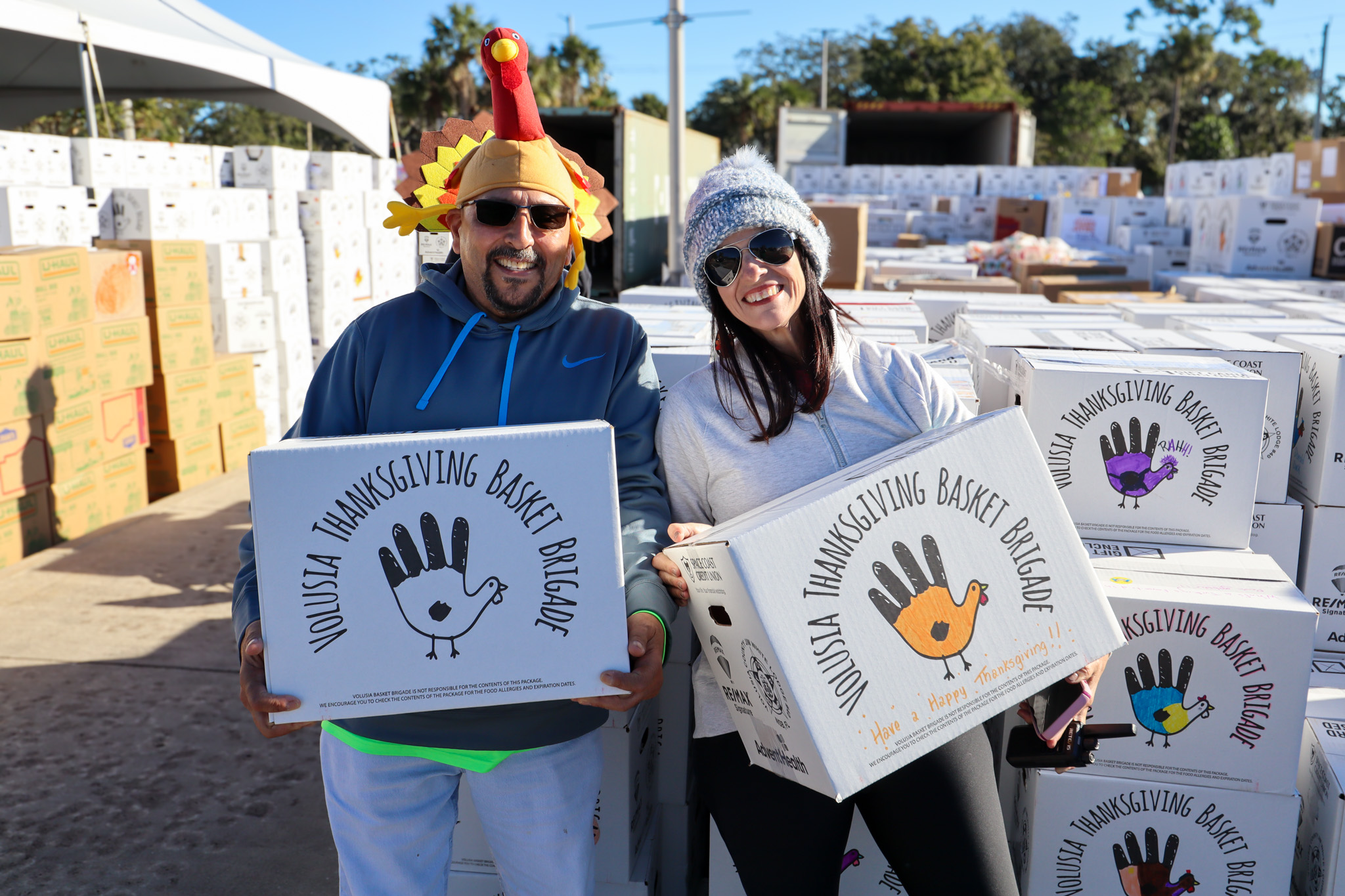 Wire 3 Volunteers at the Volusia Thanksgiving Basket Brigade Volunteers in holiday hats hold Wire 3 Thanksgiving basket boxes at the Volusia Thanksgiving Basket Brigade