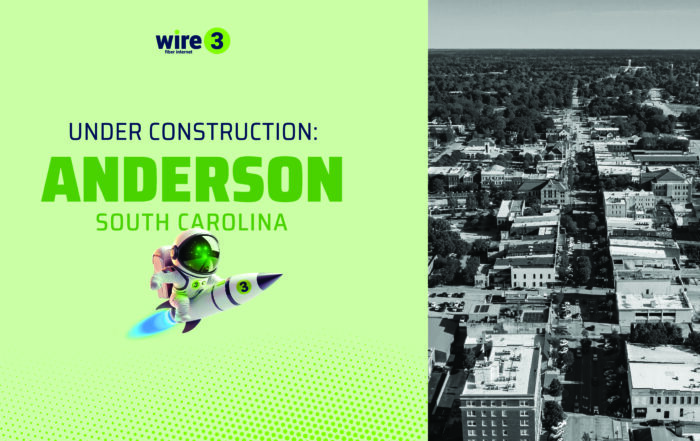 Wire 3 announcement graphic for Anderson, South Carolina, showing the Wire 3 rocket mascot beside an aerial photo of downtown Anderson, marking the start of fiber construction.
