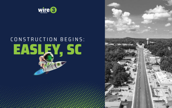 Wire 3 graphic reading “Construction Begins: Easley, SC” with a rocket mascot and an aerial view of a main road through Easley, South Carolina